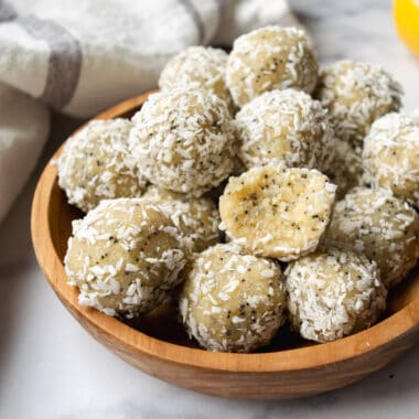 wooden bowl filled with lemon coconut poppy seed balls.