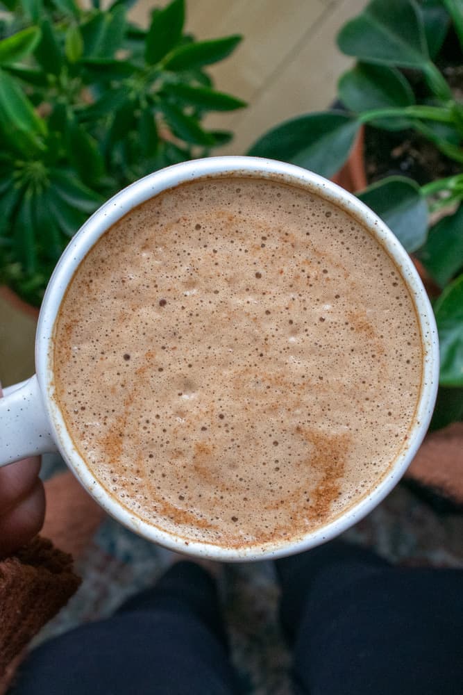 a white mug filled with foamy cacao maca latte.