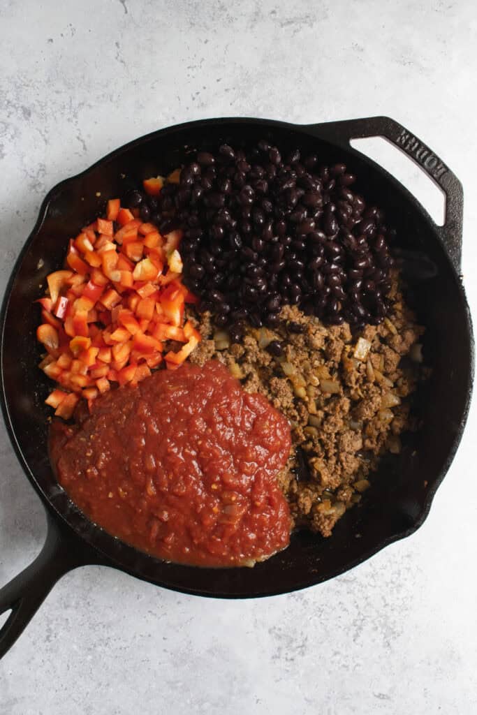 ground beef, salsa, black beans and red bell pepper in a cast iron skillet.