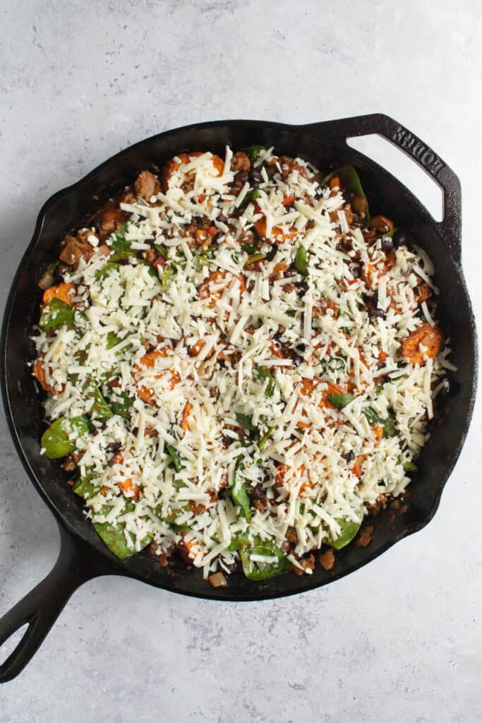 beef and sweet potato taco skillet topped with shredded cheese.
