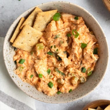 a bowl of buffalo chicken salad with crackers.