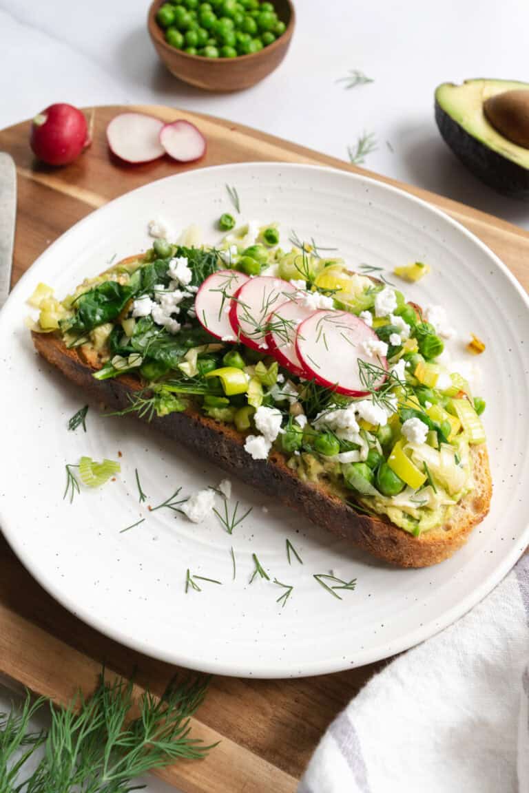 spring avocado toast on a white plate.