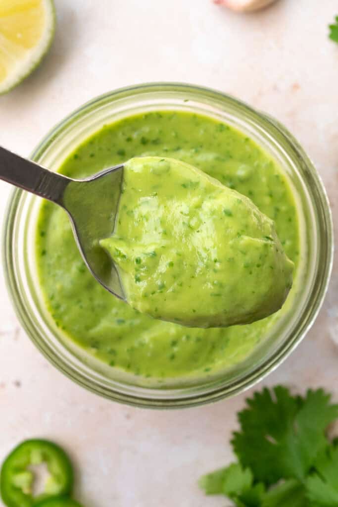 avocado cilantro dressing on a metal spoon.