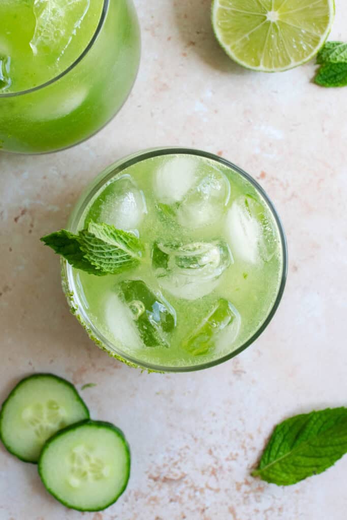 a glass of cucumber apple cider vinegar cocktail with fresh mint.