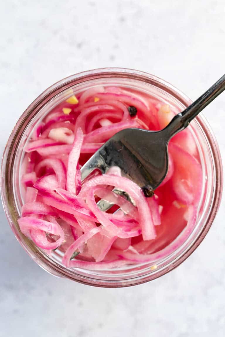 quick pickled red onions and a silver fork.