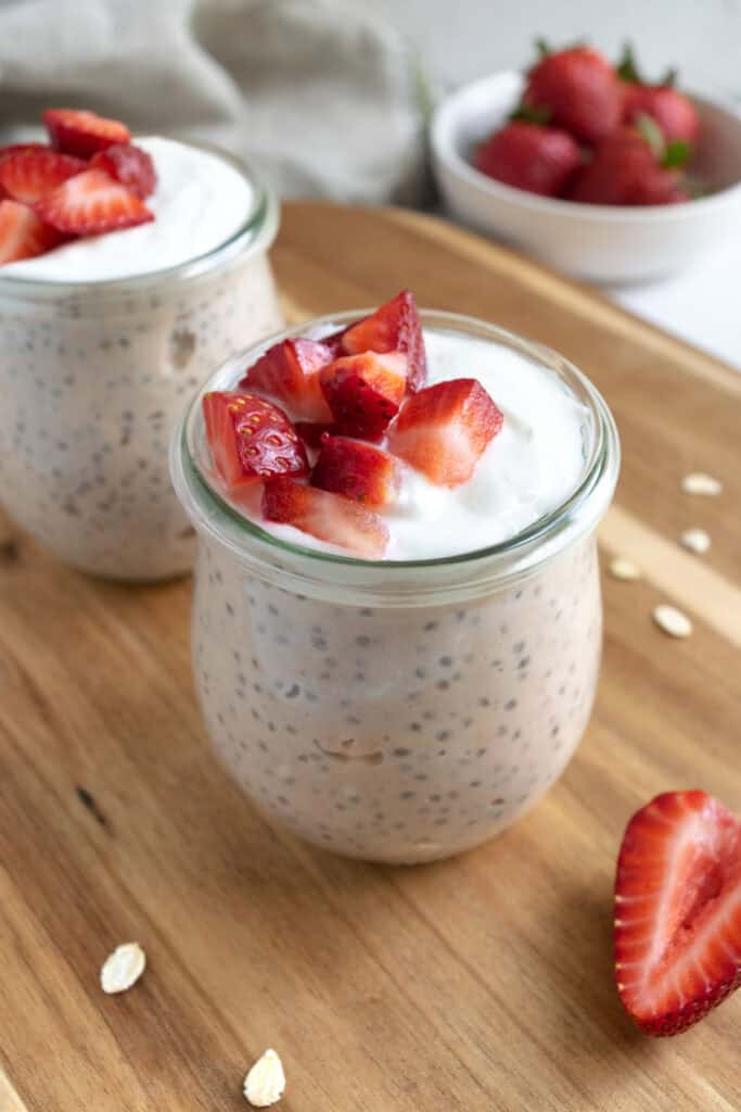 jars of strawberry overnight oats topped with yogurt and strawberries.