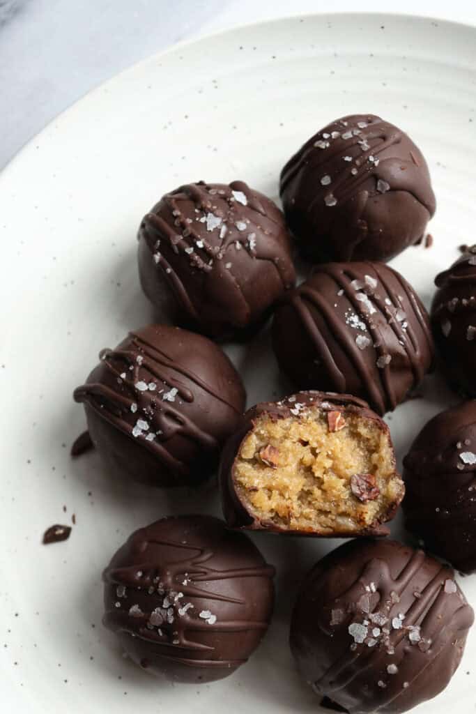 tahini miso cookie dough bites on a white plate.