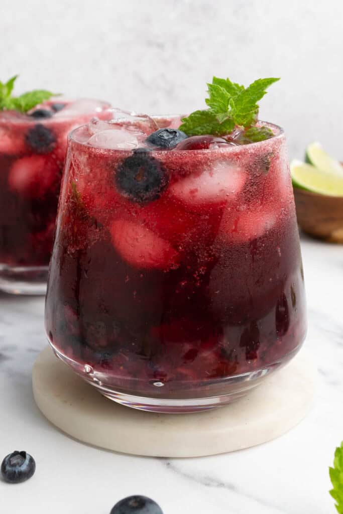 two hibiscus blueberry mocktails in a glass.