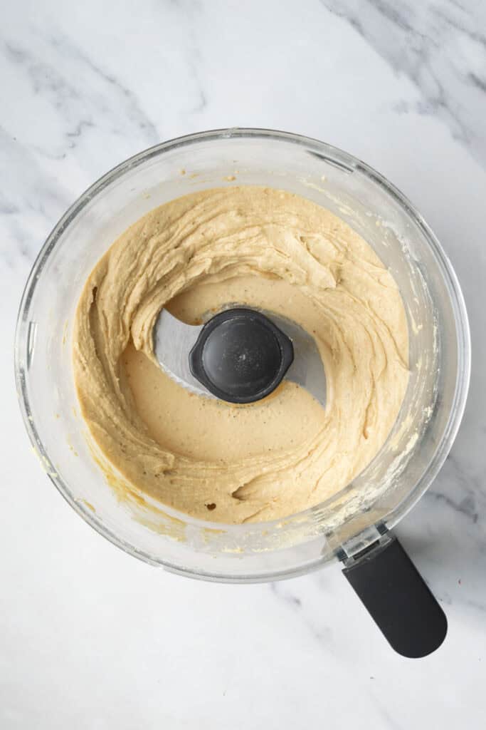 banana ice cream in the bowl of a food processor.