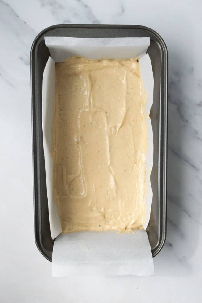 banana ice cream in a loaf pan lined with parchment paper.