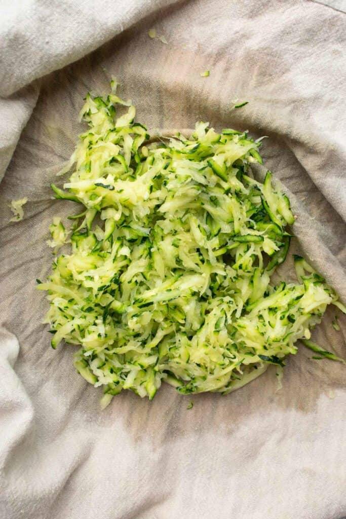 shredded zucchini in a tea towel.