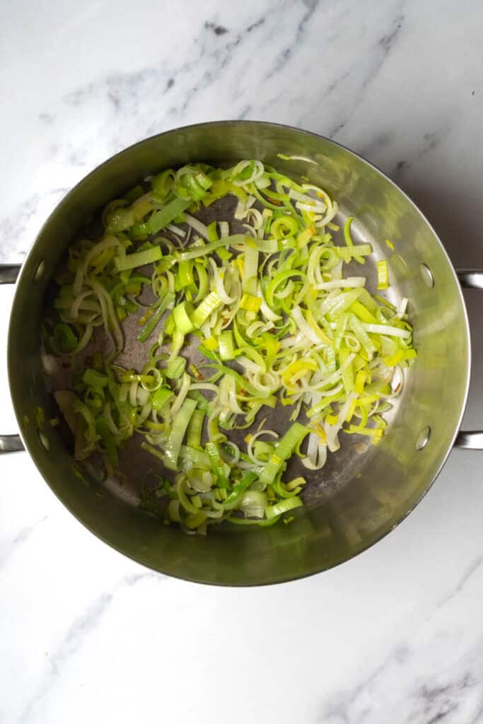 leeks being sautéed in a pot