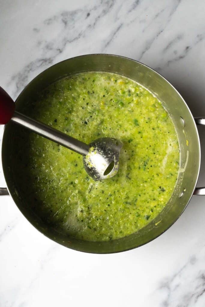 soup being blended with an immersion blender.