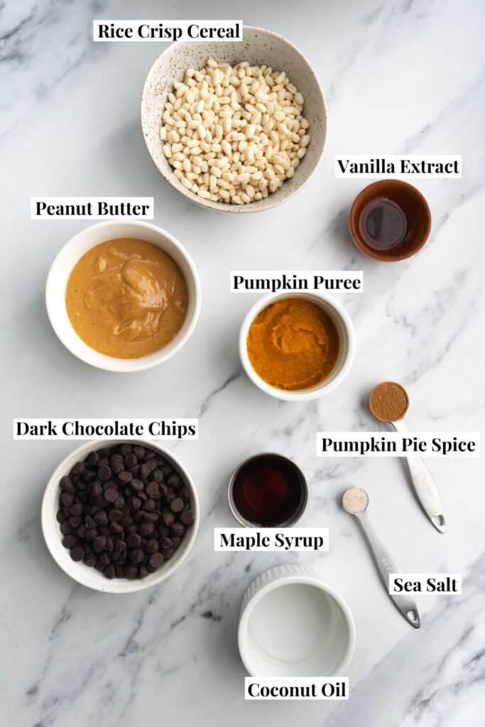 bowls and measuring spoons with pumpkin peanut butter crunch cup ingredients.