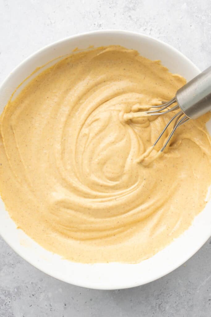 dip ingredients mixed together in a white bowl with a metal whisk.