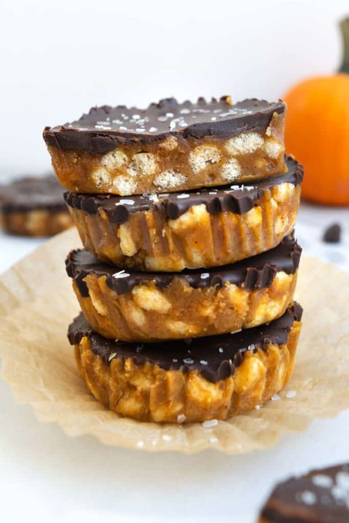 stacked crunch cups in front of an orange pumpkin.