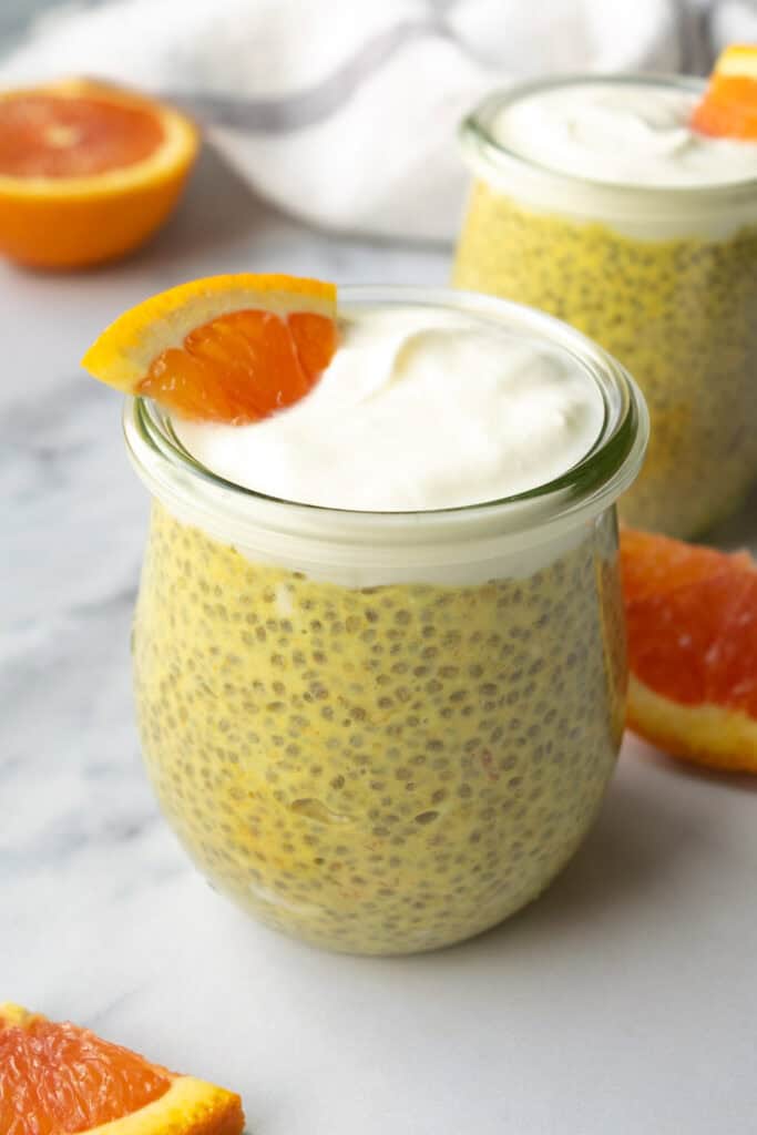 chia pudding in glass jars with fresh orange slices.