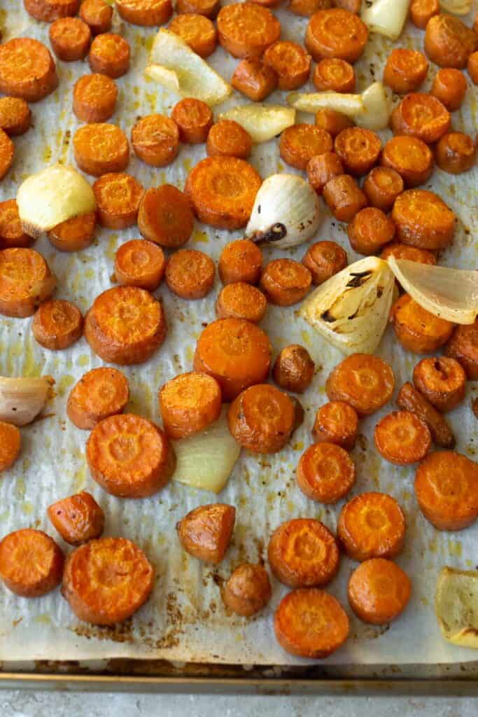 roasted carrots, onion and garlic on a baking sheet